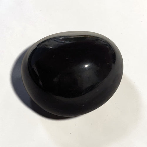 Black Obsidian Tumble Stone - Polished, one glossy black polished obsidian tumble stone on a white background.